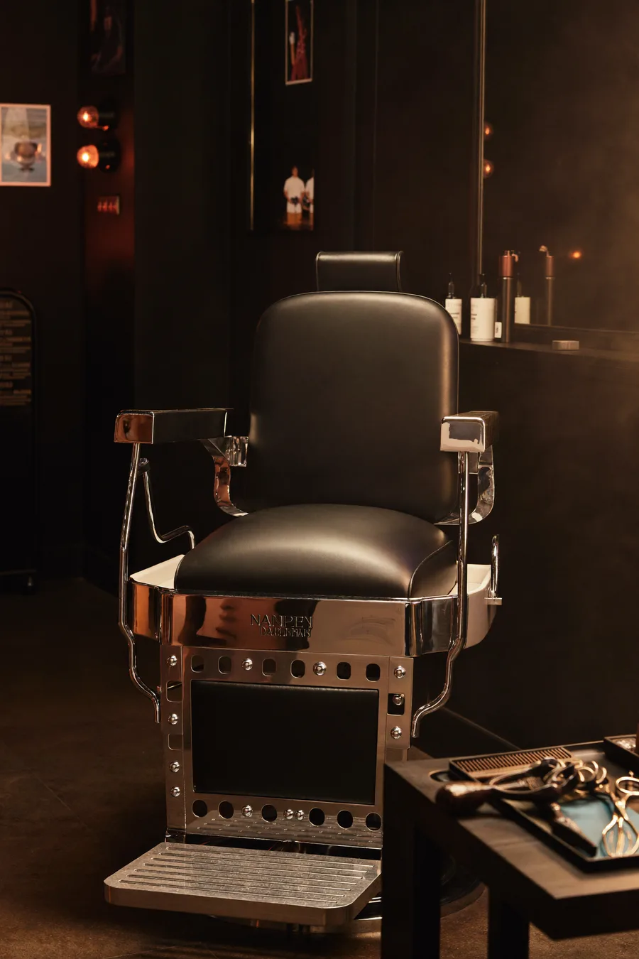 Leder-Barberstuhl mit bereitgelegtem Werkzeug auf dem Tablett, stimmungsvolle Atmosphäre