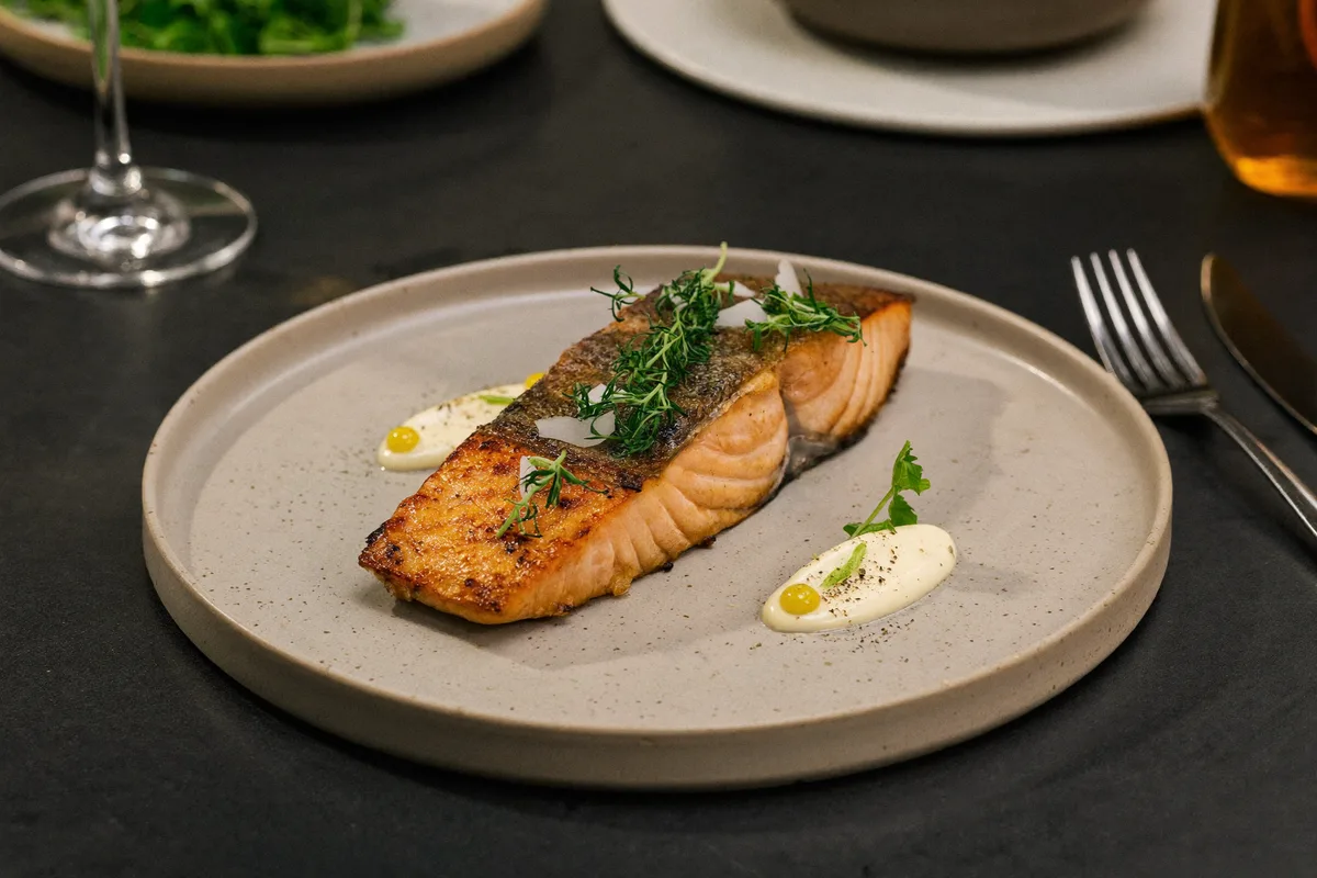 Zart gegartes Lachsfilet mit frischen Kräutern, fein angerichtet